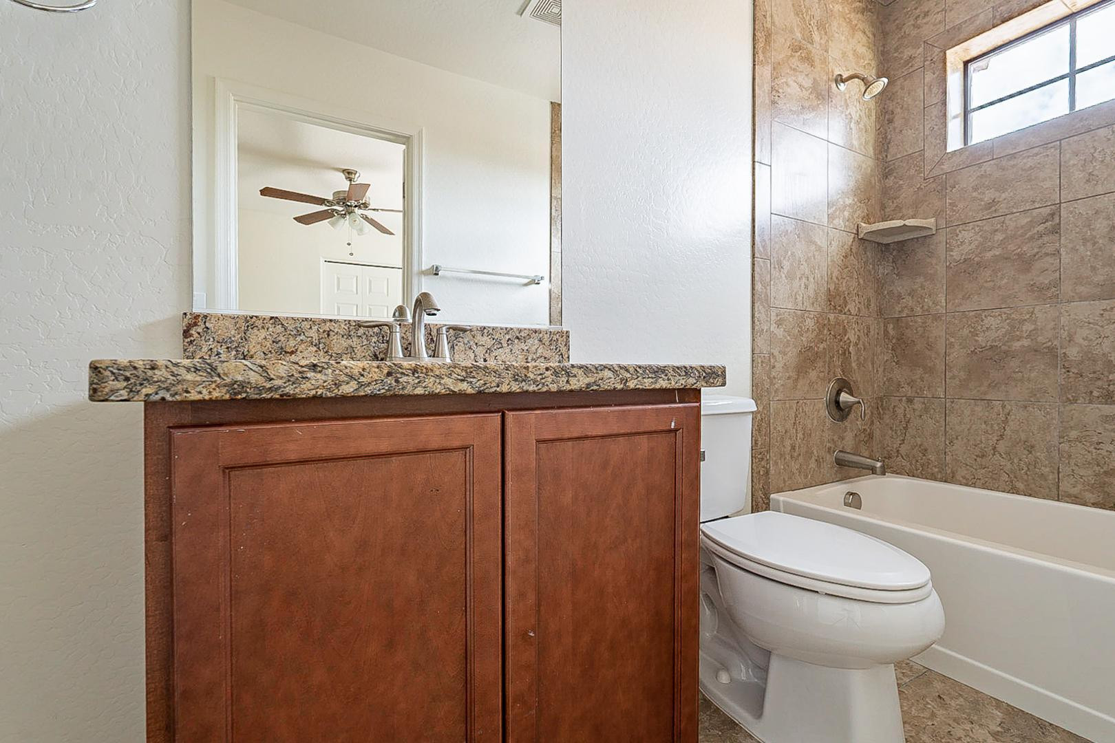 17223 North Cave Creek Road, Unit 7 Phoenix, AZ 85032 - Photo 14 of 23 a bathroom with a granite countertop sink toilet and shower