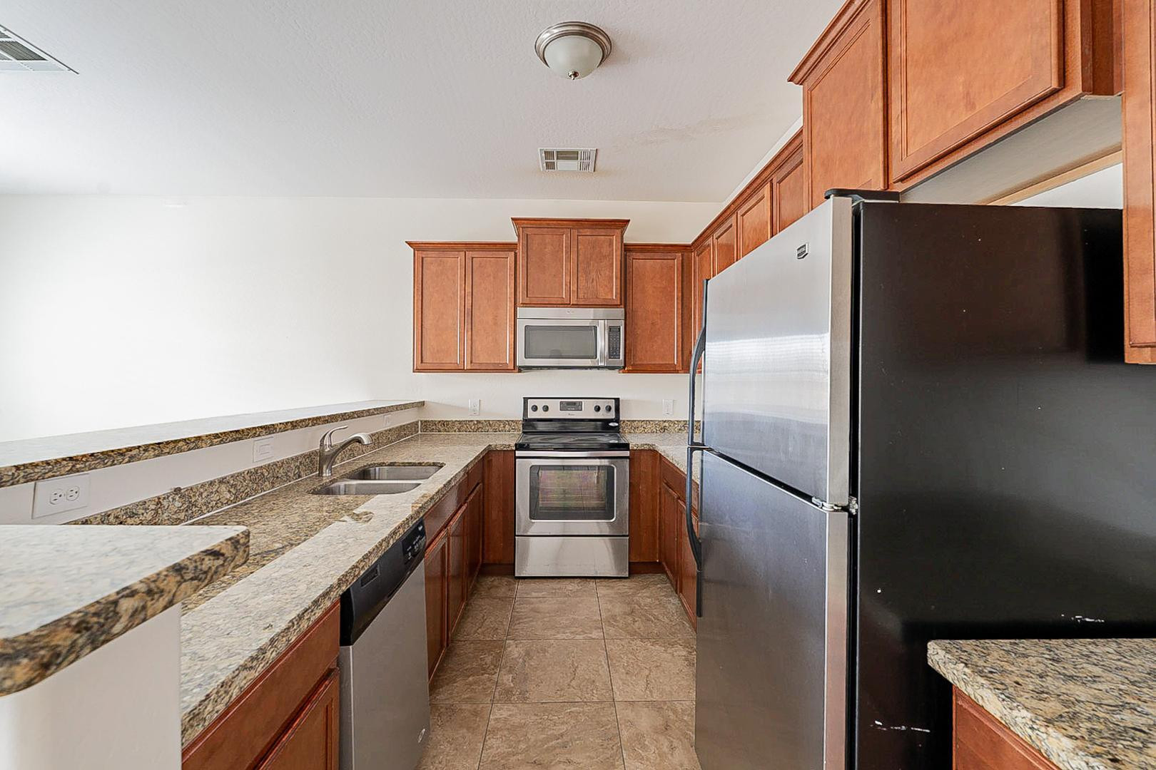 17223 North Cave Creek Road, Unit 7 Phoenix, AZ 85032 - Photo 7 of 23 a kitchen with stainless steel appliances granite countertop a stove a refrigerator and a sink