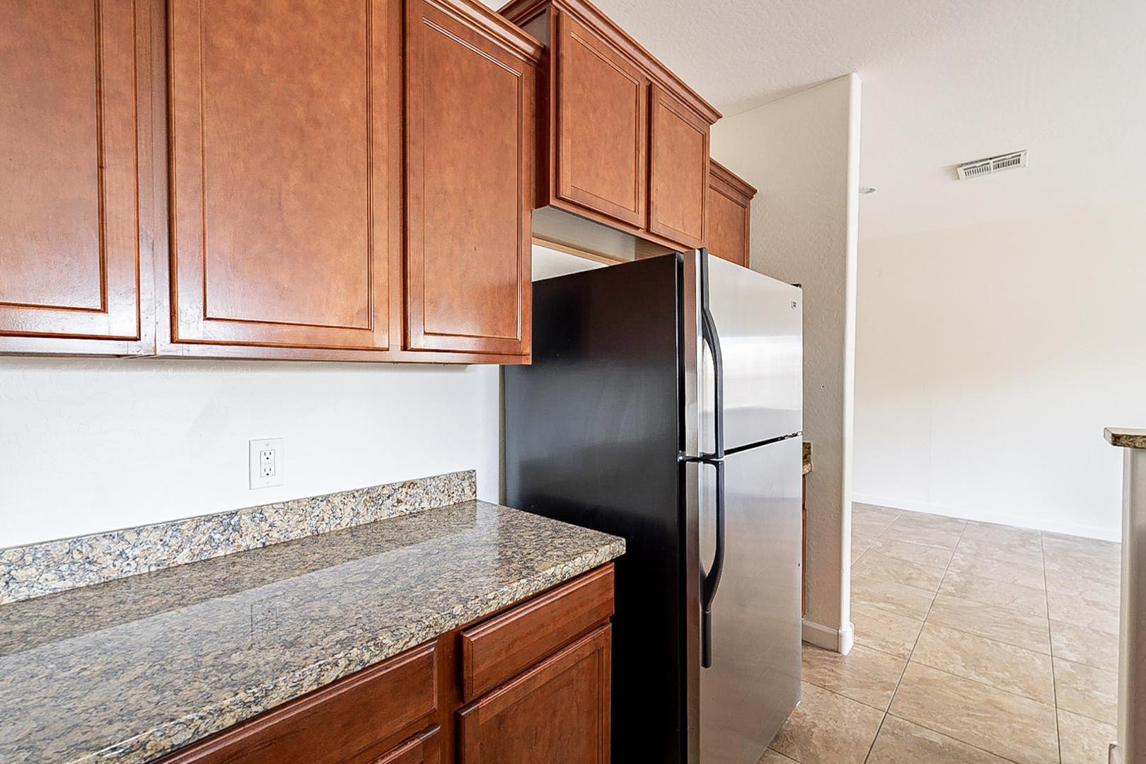 17223 North Cave Creek Road, Unit 7 Phoenix, AZ 85032 - Photo 9 of 23 a kitchen with granite countertop a refrigerator and cabinets