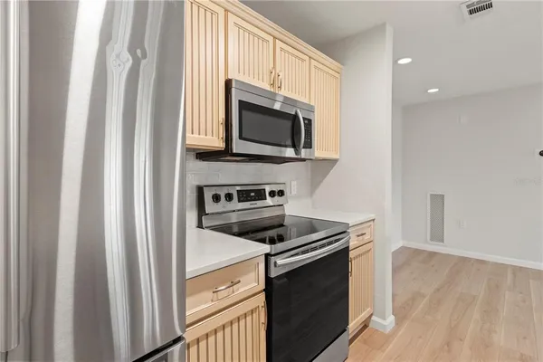 a kitchen with stainless steel appliances a stove microwave and sink
