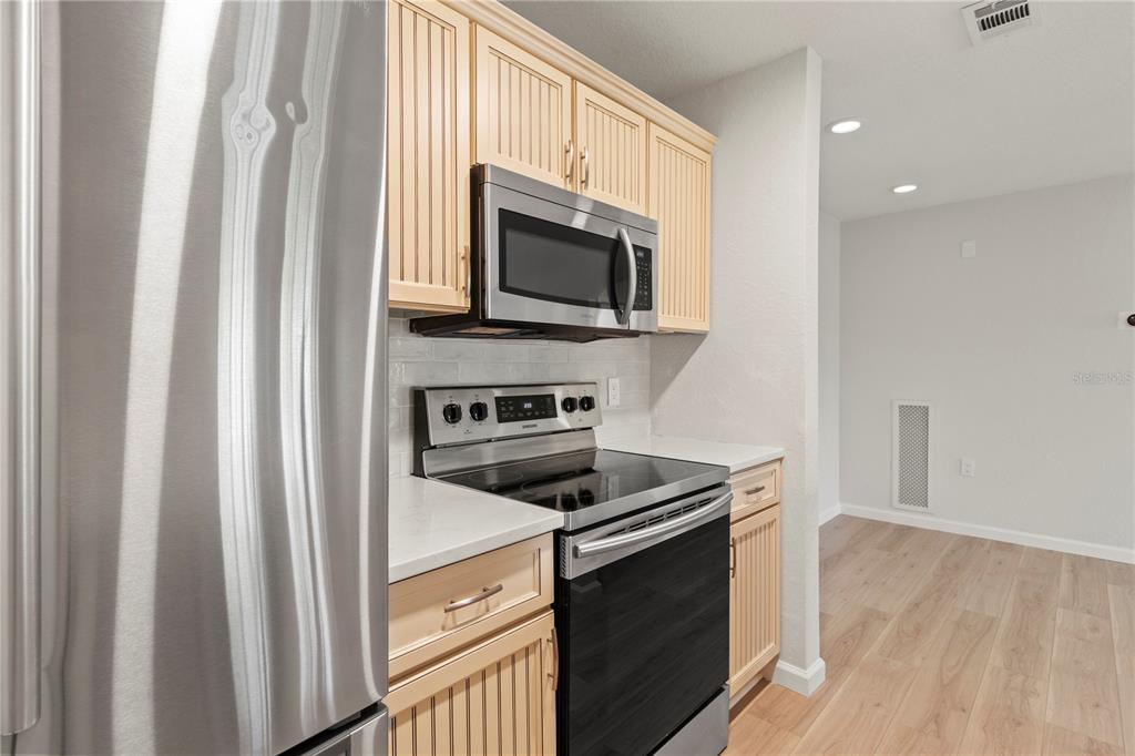 8827 Manor Loop, Unit 201 Lakewood Ranch, FL 34202 - Photo 16 of 39 a kitchen with stainless steel appliances a stove microwave and sink