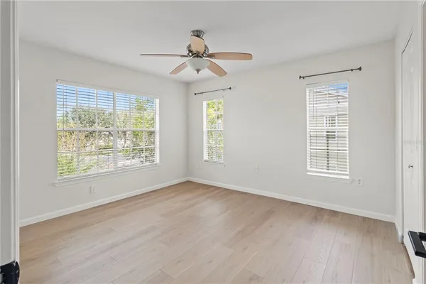 a view of an empty room with a window and wooden floor