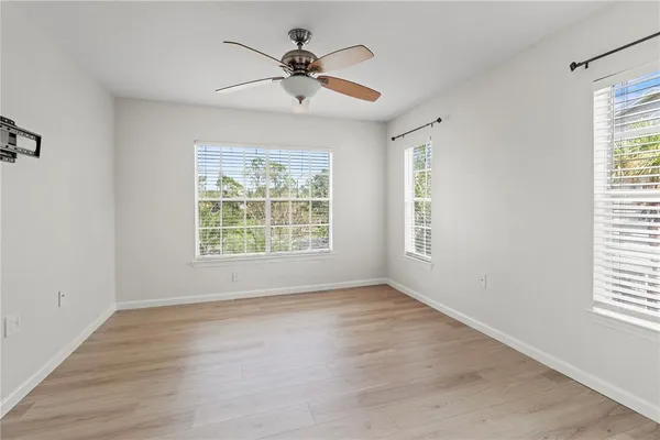 a view of room with window ceiling fan and hardwood floor