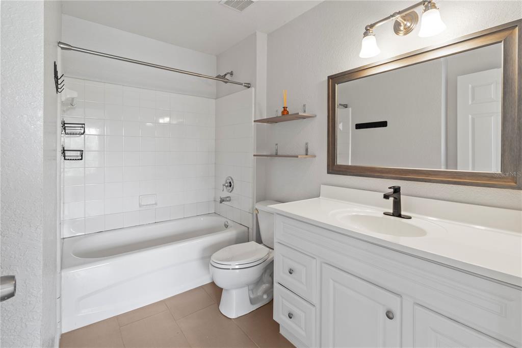 8827 Manor Loop, Unit 201 Lakewood Ranch, FL 34202 - Photo 32 of 41 a bathroom with a sink a toilet and a mirror