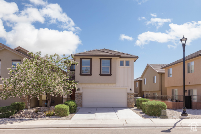 5817 Challenger Way St. George, UT 84790 - Photo 1 of 1 View of front facade with an attached garage, stone siding, driveway, and a tiled roof