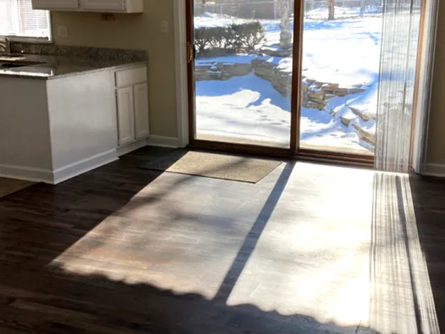 a view of open kitchen with wooden floor and a floor to ceiling window