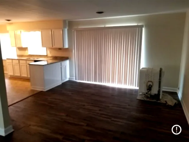 a kitchen with a window and wooden floor