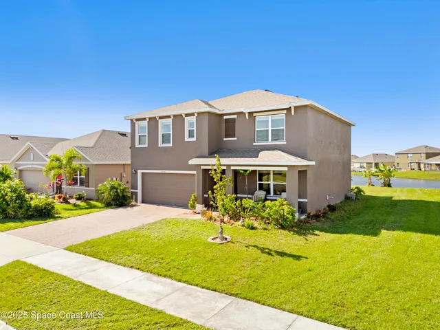 a front view of a house with yard and green space