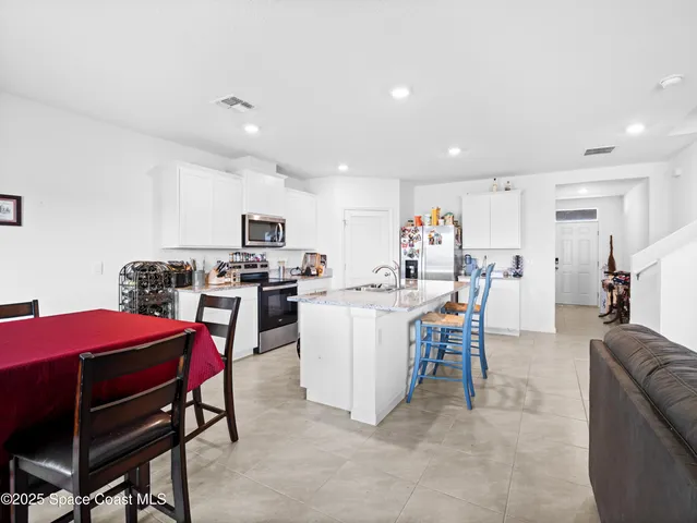 a living room with furniture a dining table and kitchen view