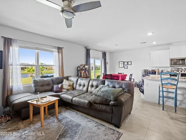 a living room with furniture kitchen view and a window