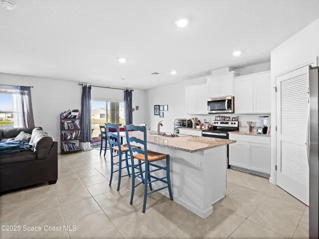 a kitchen with cabinets and chairs in it