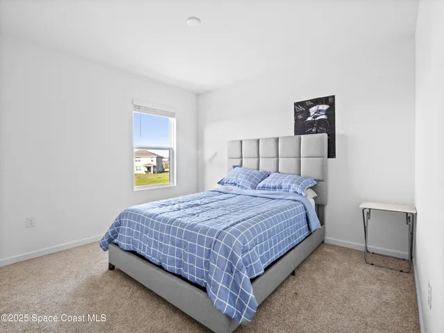 a bedroom with a bed and painting on the wall