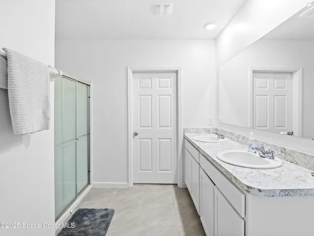 a bathroom with a granite countertop sink a mirror and a shower