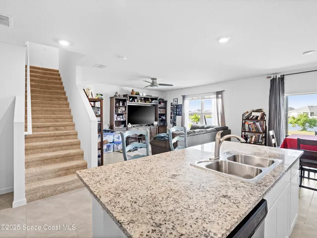 a kitchen with sink and view of living room