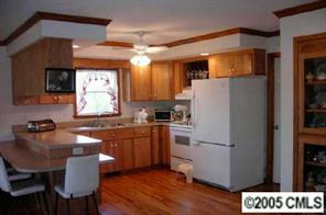 120 Lackey Mountain Road Hiddenite, NC 28636 - Photo 2 of 8 a kitchen with stainless steel appliances granite countertop a refrigerator a sink dishwasher a stove a dining table and chairs with wooden floor
