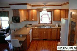 120 Lackey Mountain Road Hiddenite, NC 28636 - Photo 3 of 8 a kitchen with stainless steel appliances granite countertop a refrigerator a sink a stove and island