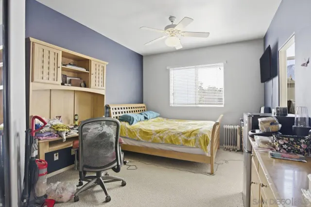 a bedroom with a bed work place furniture and a window