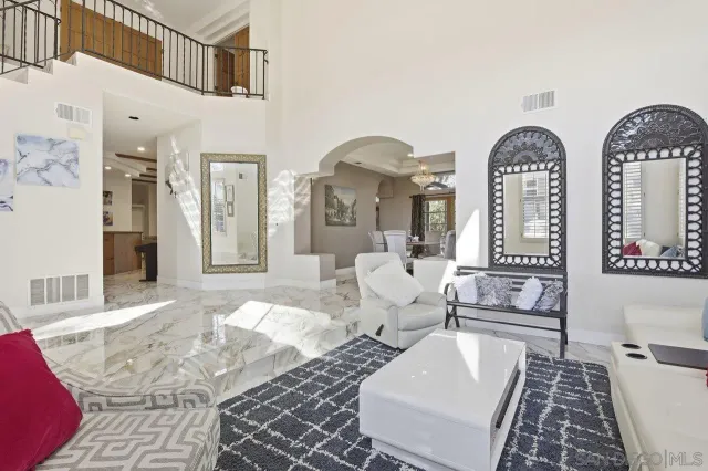 a living room with couches chairs and couches with wooden floor