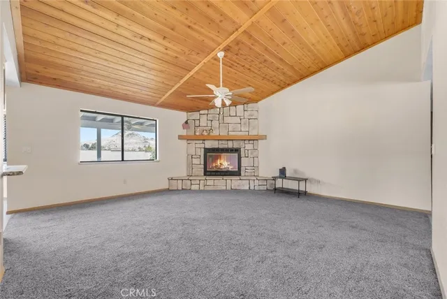 a view of an empty room with a fireplace and a window