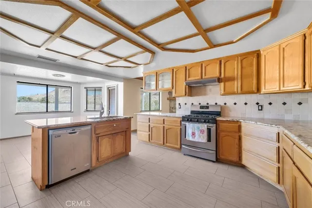 a kitchen with stainless steel appliances granite countertop a stove a sink dishwasher and a refrigerator