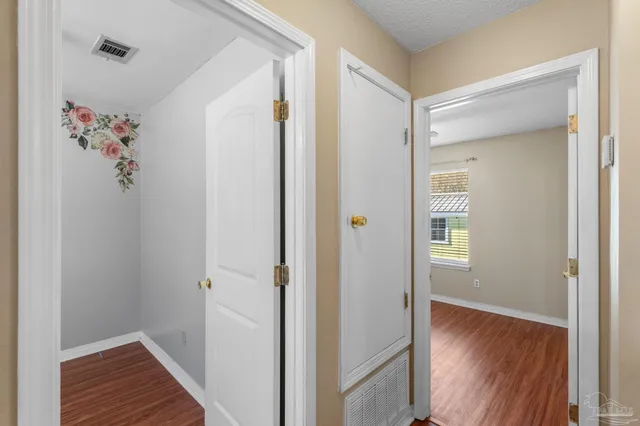 a view of a hallway with wooden floor and closet
