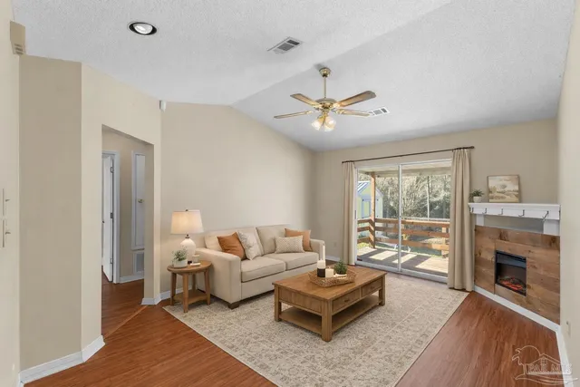 a living room with furniture a fireplace and a flat screen tv