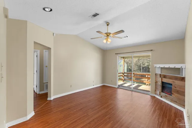 an empty room with wooden floor and fireplace