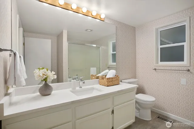 a bathroom with a toilet a sink and mirror