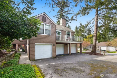 a view of a house with a yard and large tree