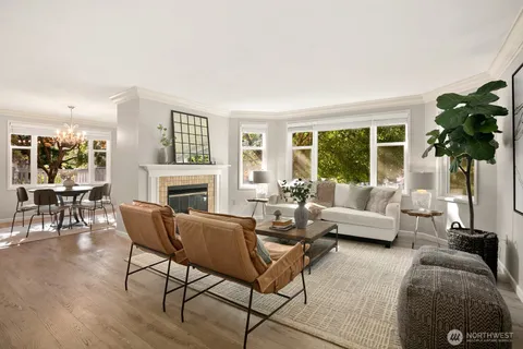 a living room with furniture a fireplace a lamp and a large window