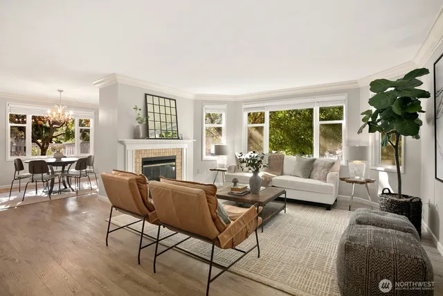 a living room with furniture a fireplace a lamp and a large window