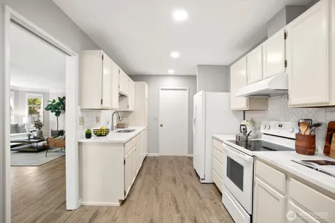 a kitchen with white cabinets and white appliances