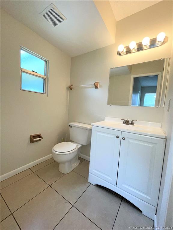 402 South 14th Street, Unit B Fort Pierce, FL 34950 - Photo 7 of 9 a bathroom with a toilet sink and mirror