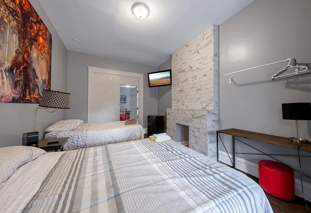 a bedroom with a bed and a flat tv screen on dresser