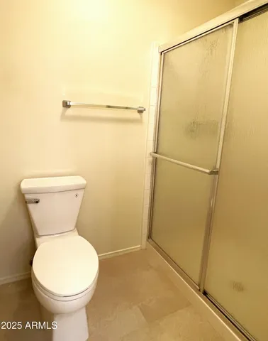 a bathroom with a toilet and a shower
