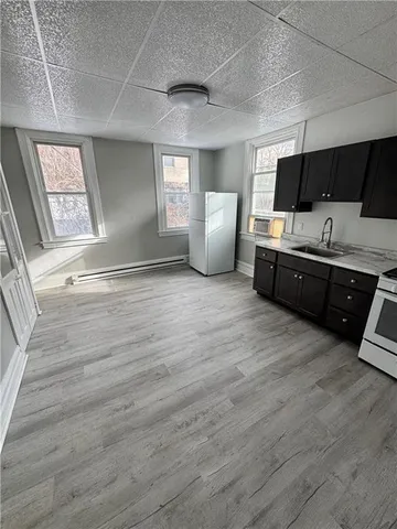 a view of a kitchen with wooden floor and electronic appliances