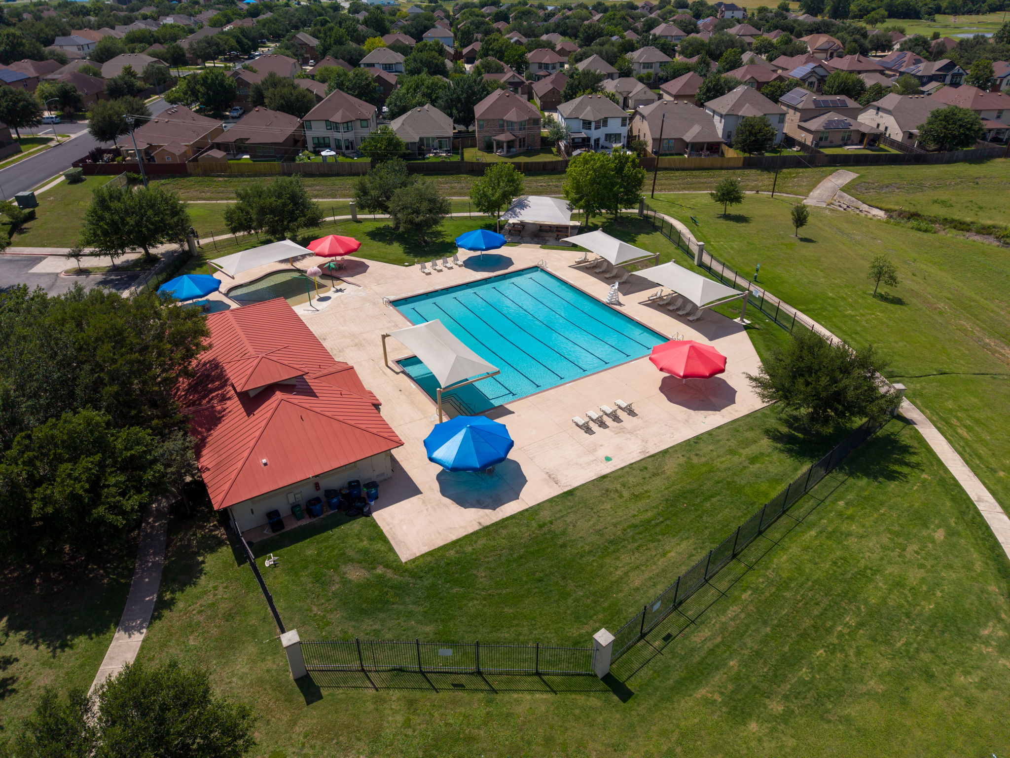 8813 Wiley Way Austin, TX 78747 - Photo 35 of 39 An aerial perspective reveals a vibrant community pool area surrounded by lush green spaces and residential homes.