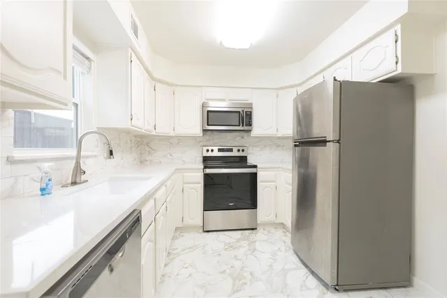 a kitchen with a refrigerator sink and cabinets