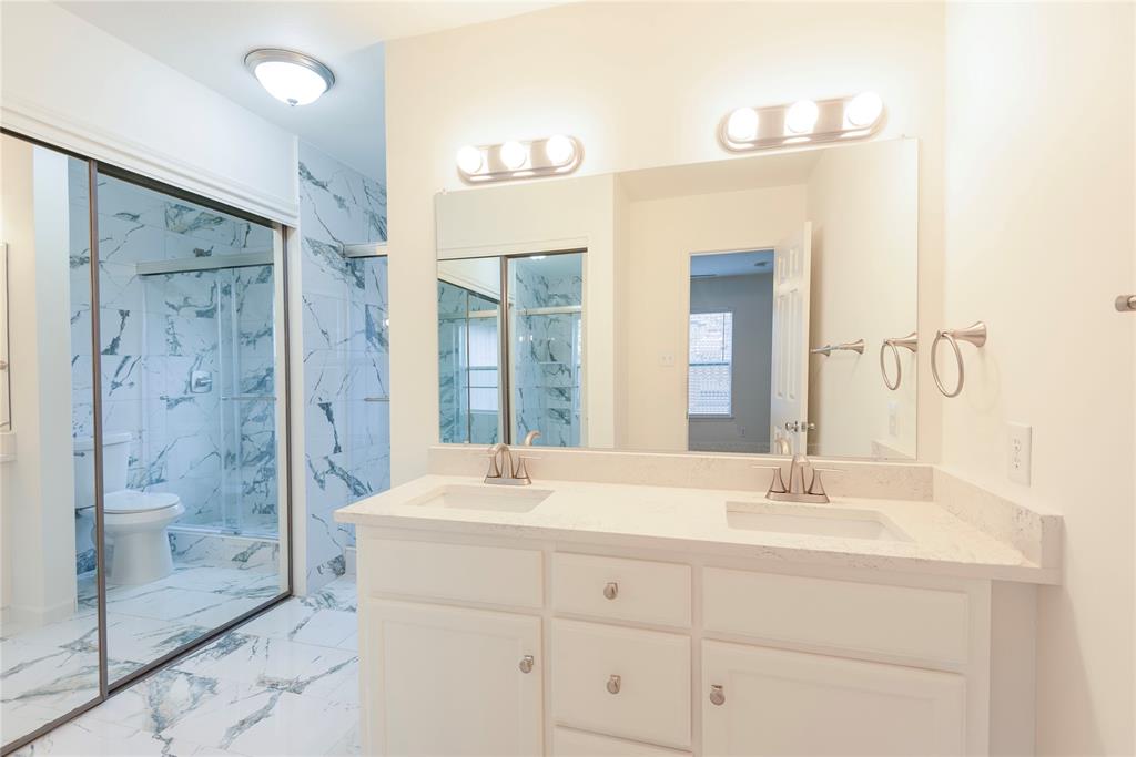 4080 Windhaven Lane Dallas, TX 75287 - Photo 19 of 24 a bathroom with a double vanity sink mirror and shower