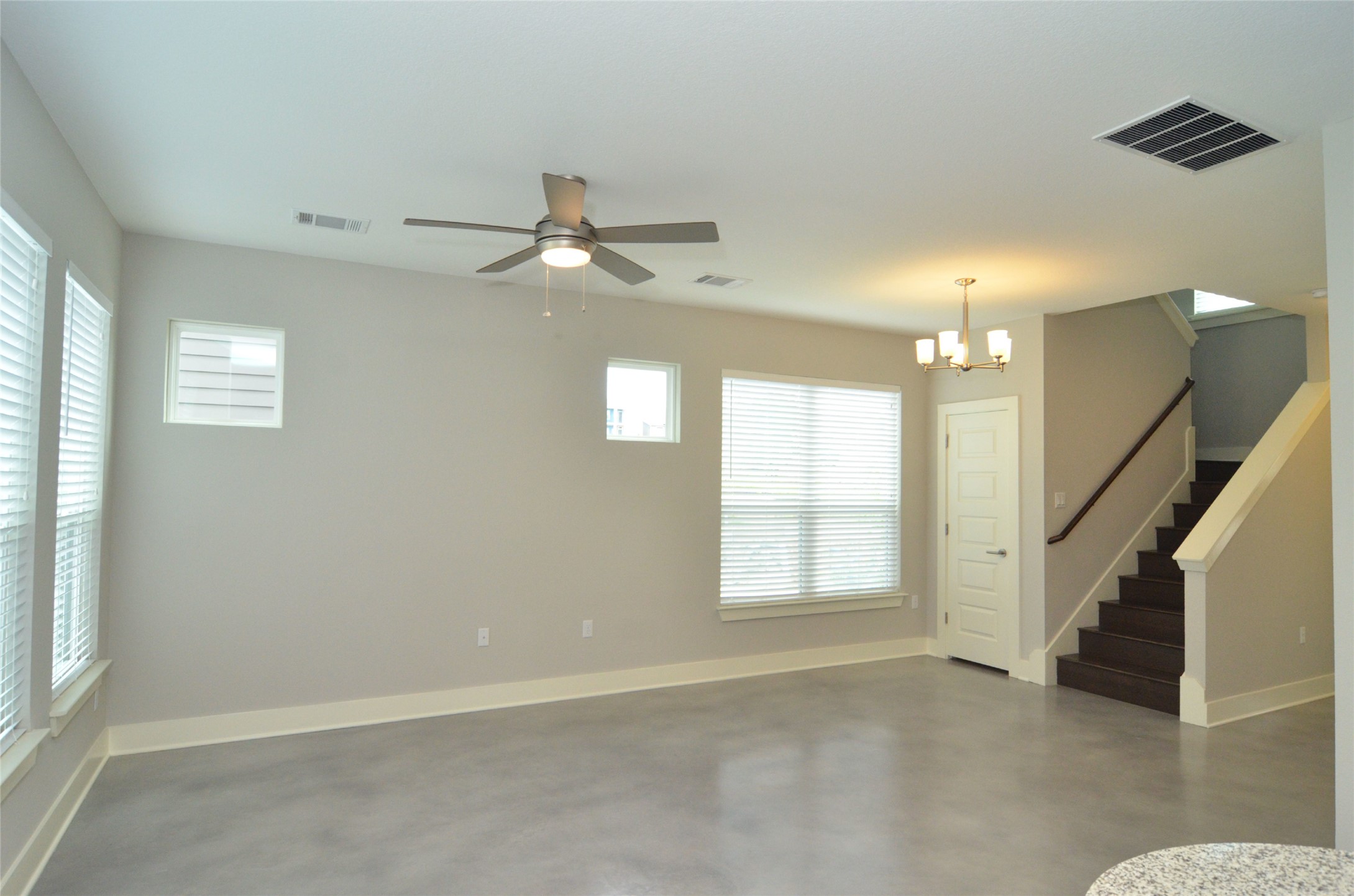 1916 Cleese Drive Austin, TX 78741 - Photo 9 of 36 A living area with polished concrete flooring and a modern ceiling fan, creating an airy and functional space.