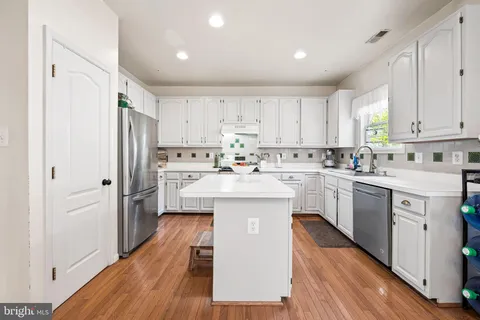 a kitchen with white cabinets and white appliances