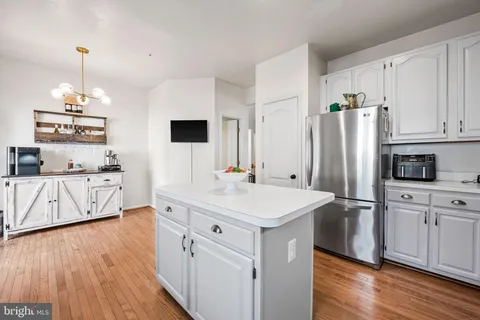 a kitchen with stainless steel appliances a sink cabinets and wooden floor