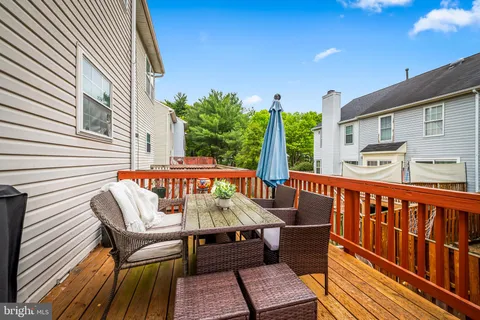a roof deck with a table and chairs and potted plants