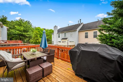 a view of a patio with table and chairs with wooden floor and fence