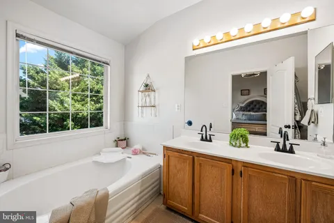 a bathroom with a double vanity sink a mirror and a window