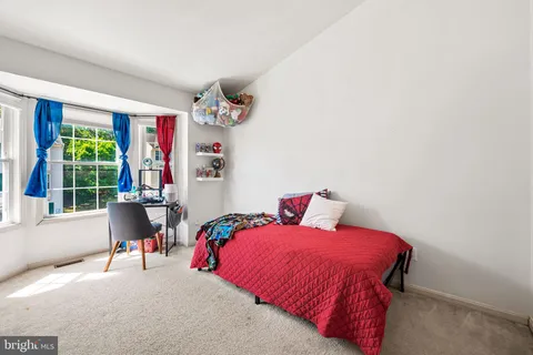 a bedroom with a bed and a large window