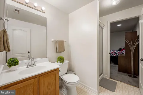 a bathroom with a granite countertop toilet sink and mirror