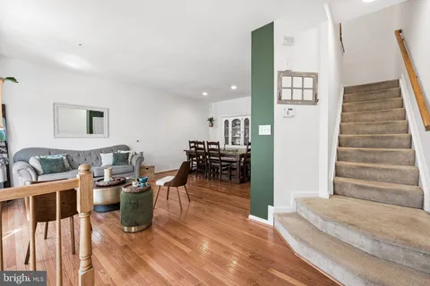 a living room with furniture a wooden floor and next to a window