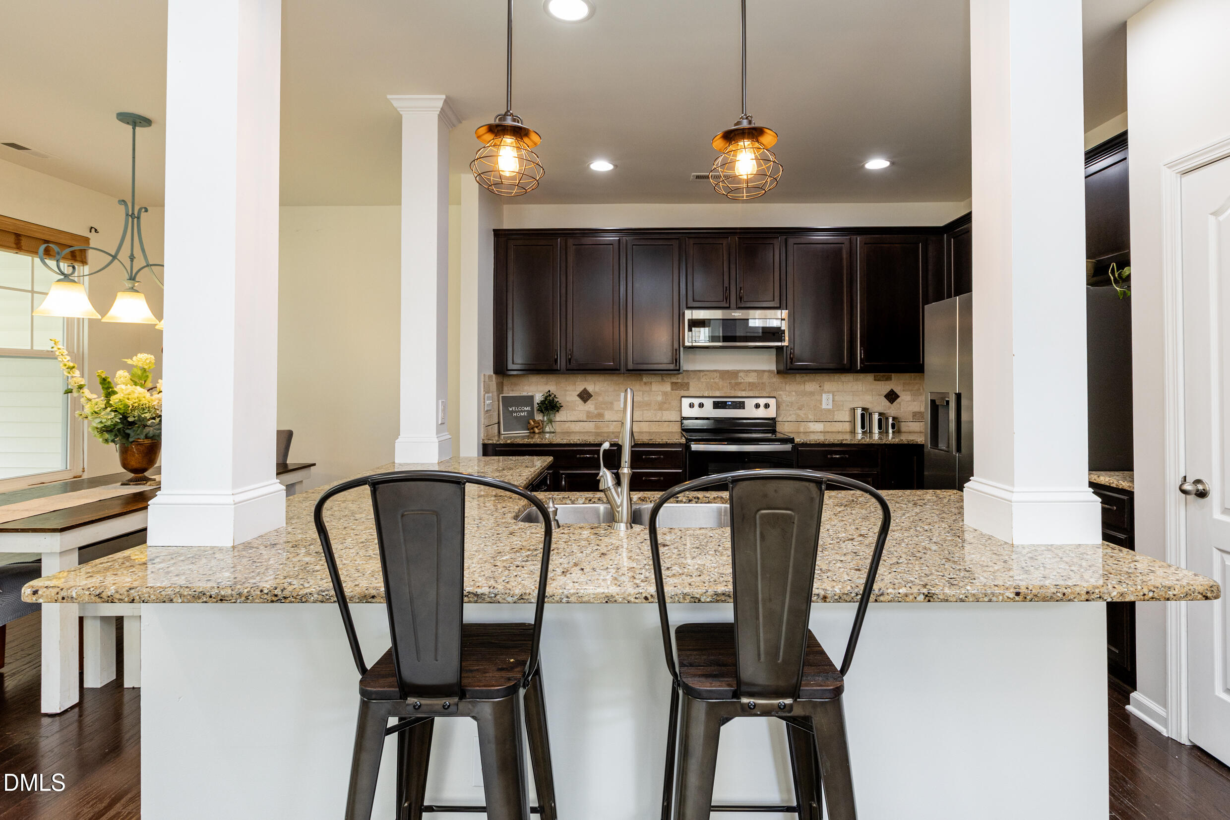 7250 Terregles Drive Raleigh, NC 27617 - Photo 4 of 19 a kitchen with stainless steel appliances granite countertop a sink a microwave a refrigerator and chairs