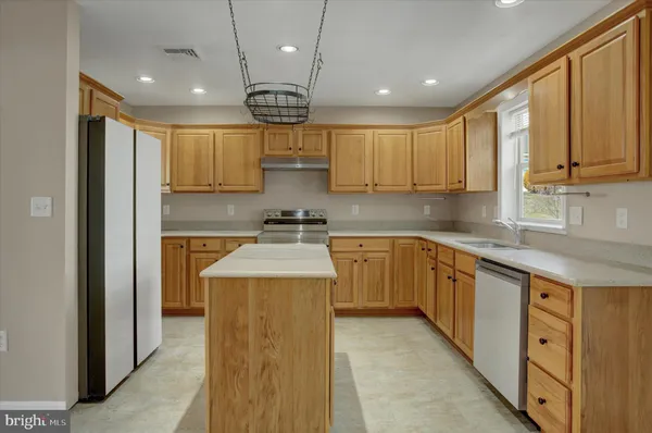 a kitchen with a sink a counter top space cabinets and stainless steel appliances